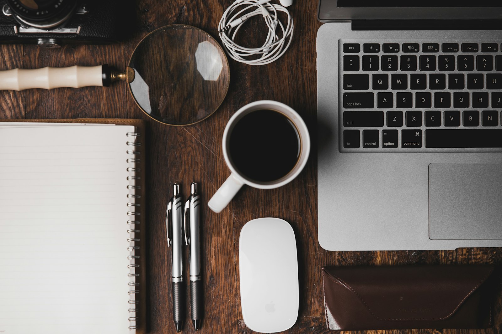 A freelancer's desk in Seoul with a laptop, notebook and coffee during an evening planning session