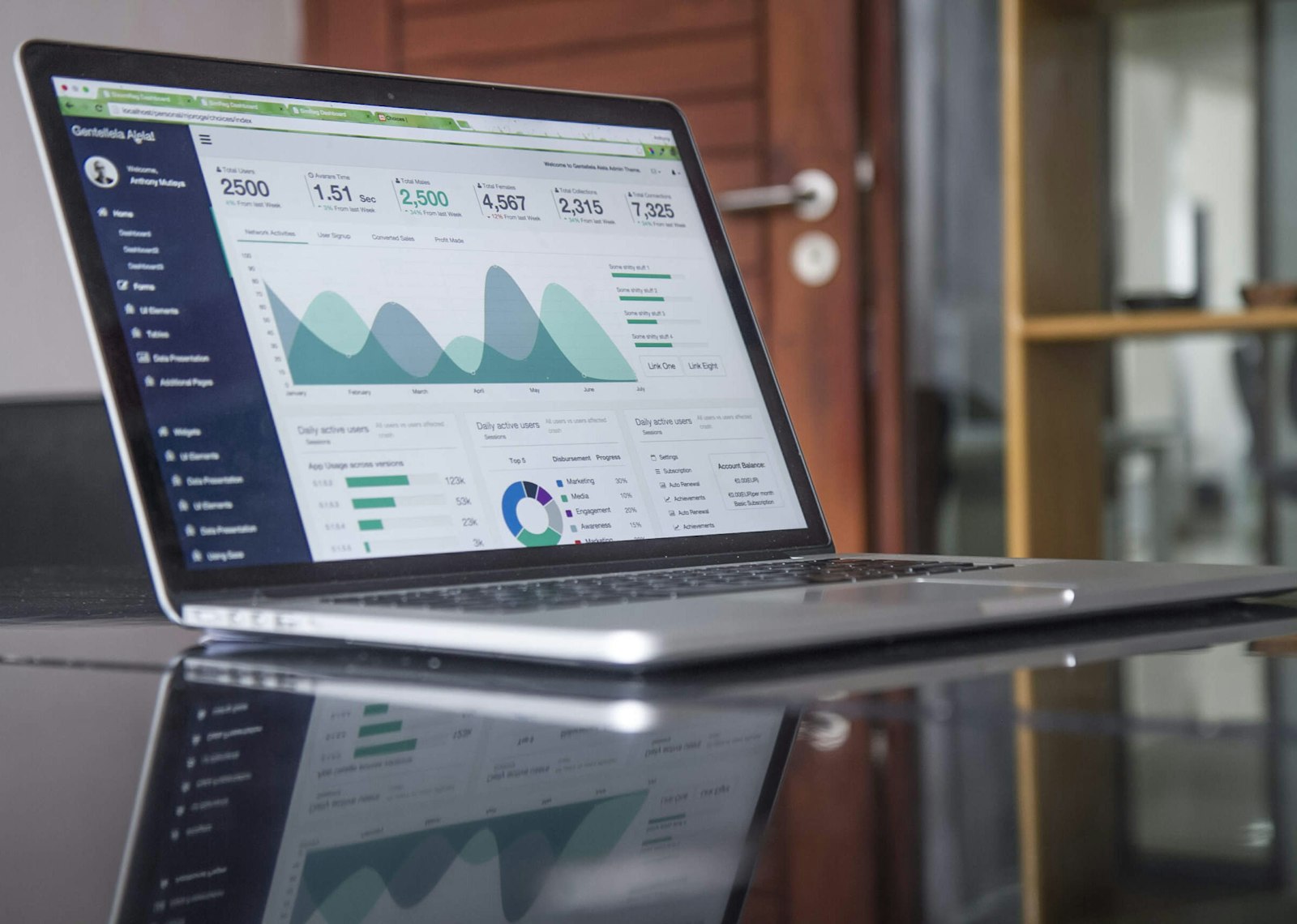 A laptop showing a cash-flow spreadsheet with monthly income and expense columns